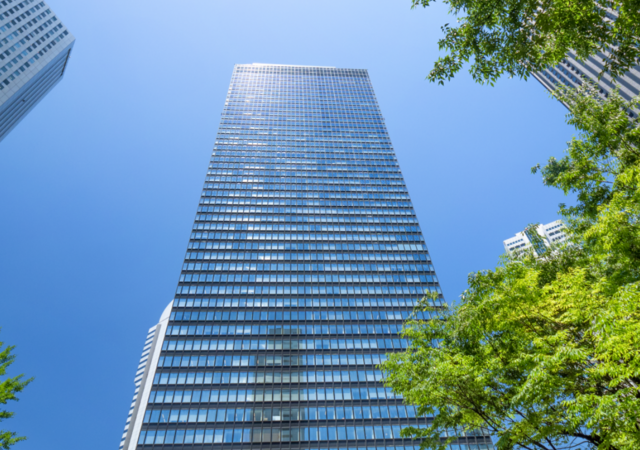 sunlit skyscraper surrounded by trees