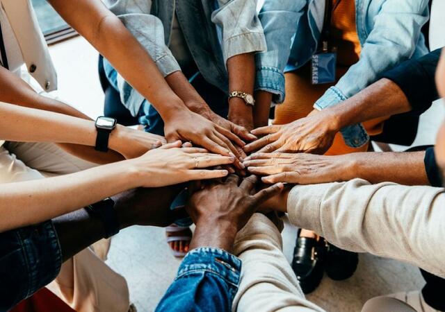 A group of people with their hands in the middle
