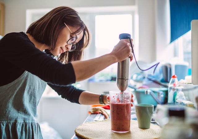 A person using a hand mixer