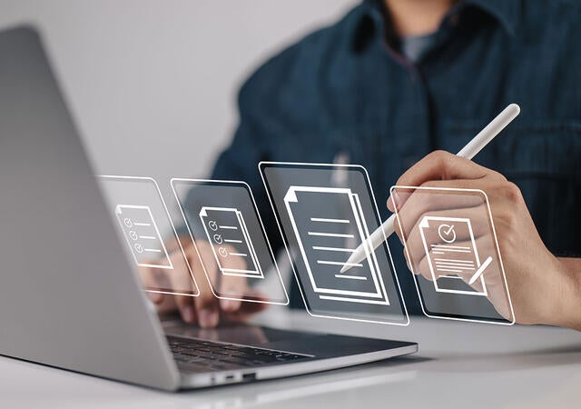 Person holding a stylus and signing an online document