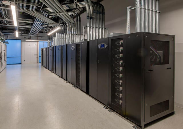 Row of server cabinets and power distribution infrastructure within a data center