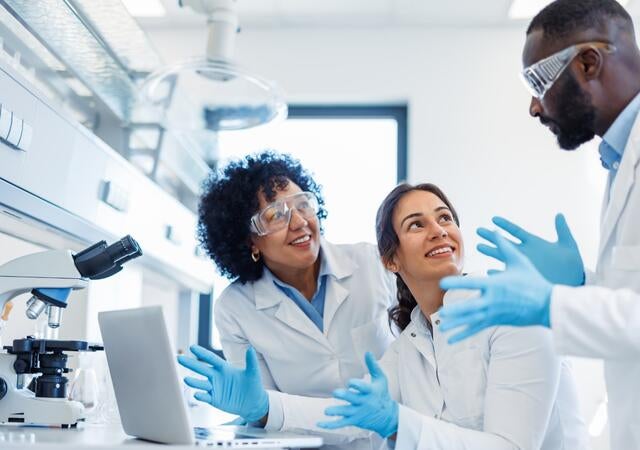 Three laboratory technicians discussing work