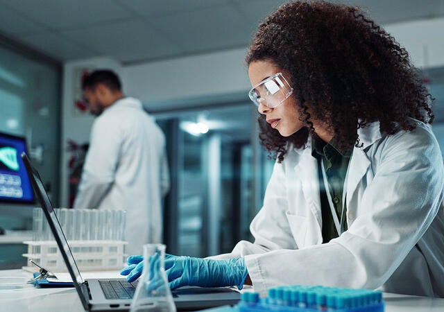 A person working on a laptop in a laboratory 