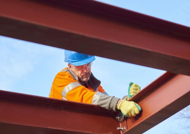 A steel worker and steel beams