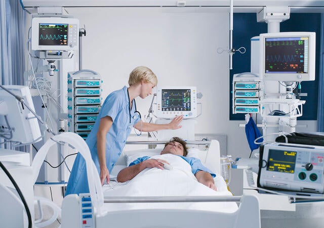 A doctor checks on a patient in a medical bed