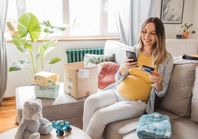 A pregnant person using a mobile device
