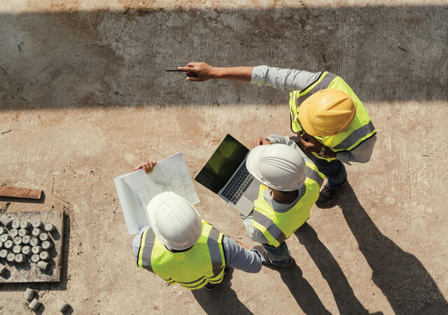 Three engineers working on schematics