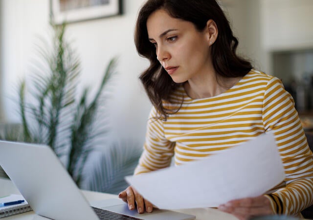 woman in striped shirt using laptop