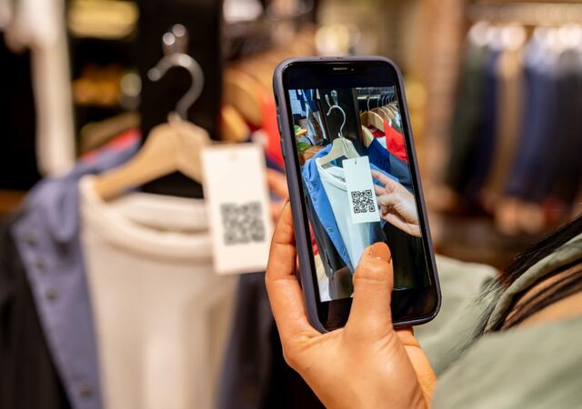 Person taking picture of a tag on a sweater