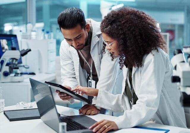Science, teamwork and scientist with tablet in laboratory for communication, pharmaceutical review or planning. Employees, collaboration and technology for research, discussion and digital analysis