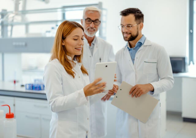 Modern Medical Research Laboratory: Science Research, Work and People Concept - Team of Scientists With Tablet Pc Computer Working in Laboratory