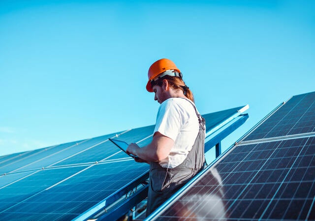 Person looking at a tab near solar panel