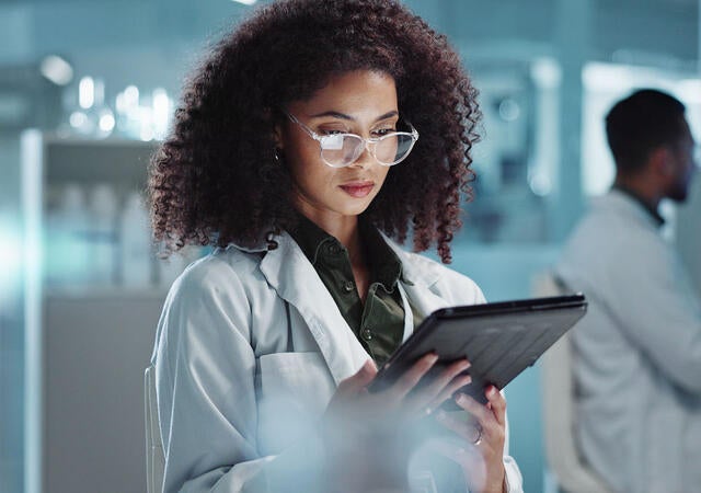 Tablet, reading and woman scientist in laboratory working on medical research, project or experiment. Science, career and female researcher with digital technology for pharmaceutical innovation.