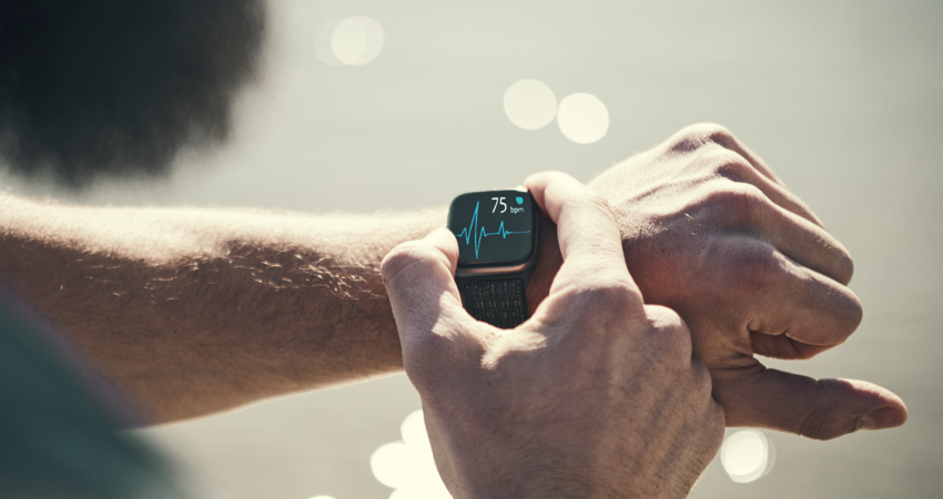 Man running outdoors running checking smart watch taking a break