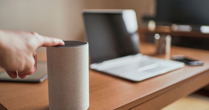 Smart speakers and a laptop computer on a desk in a home office