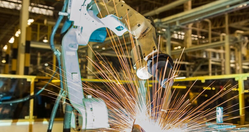 Robotic arm welding in a car factory