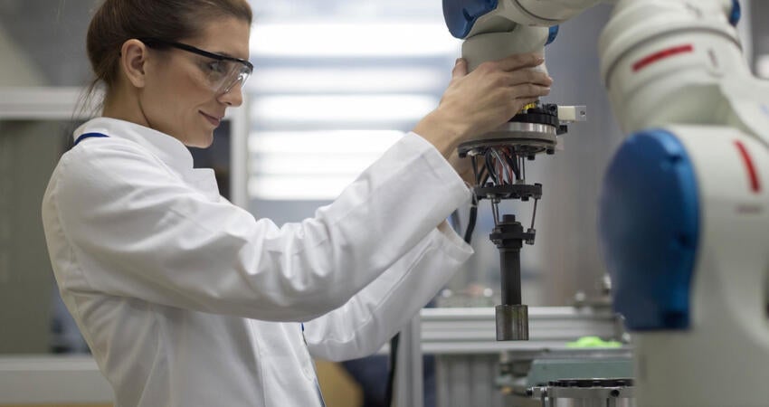 Engineer working with a robotic arm