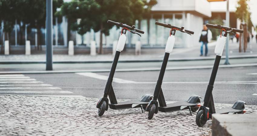 Three electric scooters outdoors