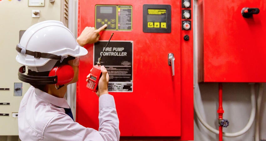 Inspector checking industrial fire control system.