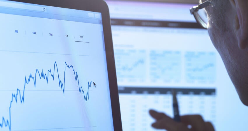 Financial services, stock analyst researching share price data of a company on the computer