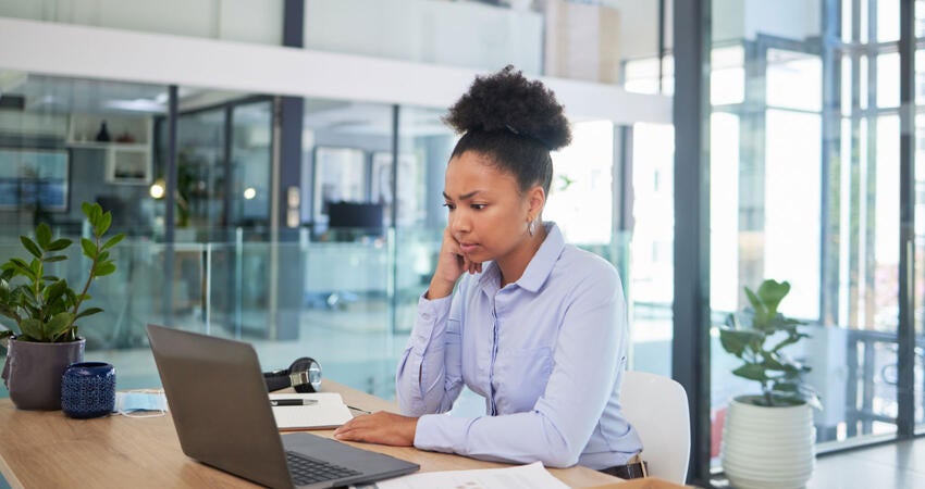 concerned office worker looking at laptop