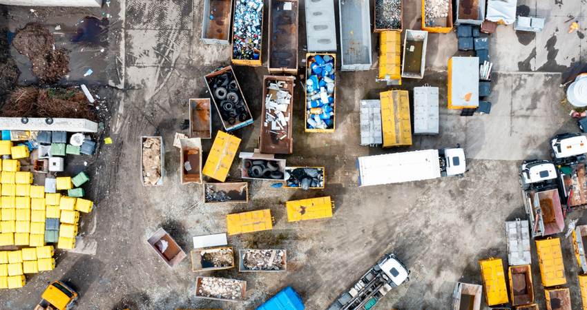 Dumpsters and garbage trucks sorting and recycling waste in an urban environment.
