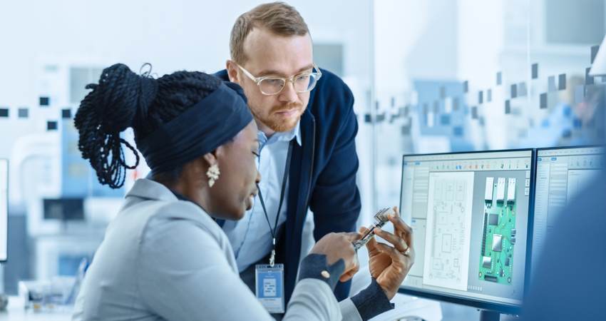 Two colleagues reviewing a circuit board