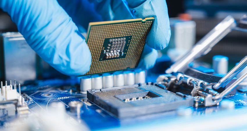 Person wearing a latex glove as they install a CPU on a circuit board