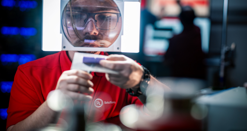 Man in red UL Solutions polo inspecting device