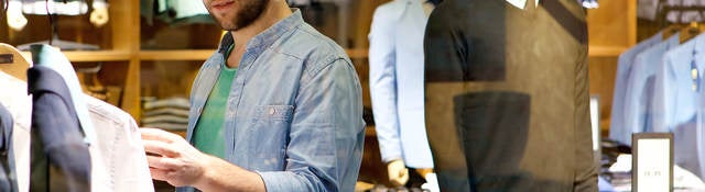 A man browses different articles of clothing.