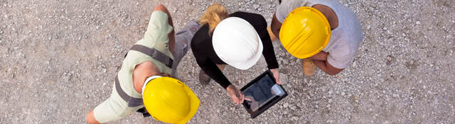 Workers on-site collaborating on a tablet