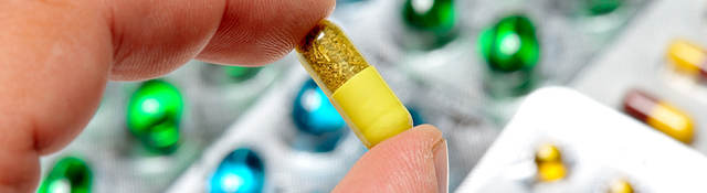 Close-up of hand holding a pill