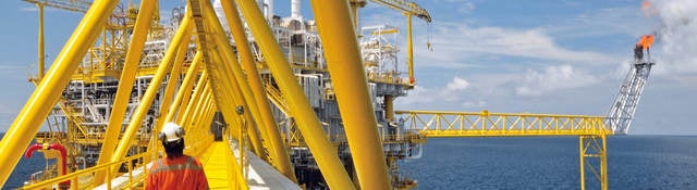 A worker walking on a platform of an offshore rig. 