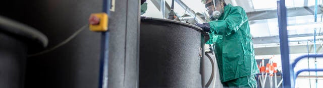 Worker at mixing tanks in chemical factory