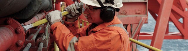 Working in a hard hat working in a petroleum refinery