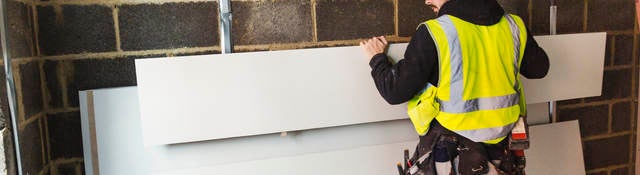 Construction worker using drywall