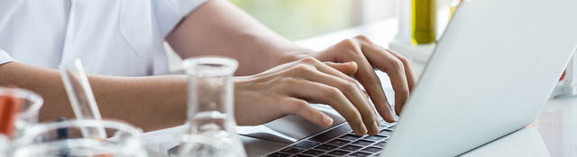 Person working on laptop at lab bench