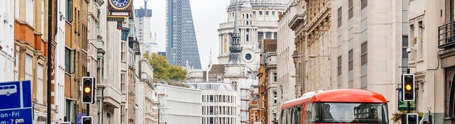 People walking on a busy street in London, England near St. Paul's Cathedral.