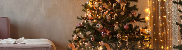 A living room with pre-lit Christmas tree and other lit decorations