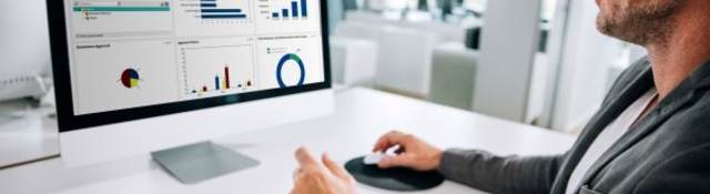 man at computer with data on screen