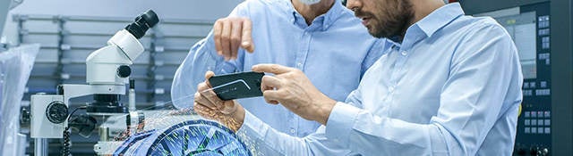 two male laboratory technicians observing a digital model