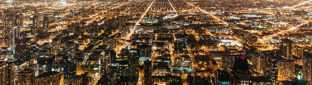 Cityscape at night with many lights from homes, businesses, roads