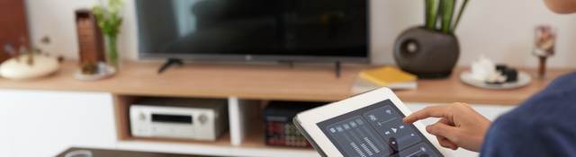 Woman controlling a smart home system with a tablet 