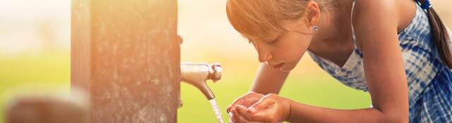 Girl drinking water from fountain