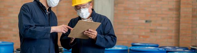 Men in PPE working in chemical warehouse