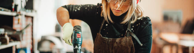 Female carpenter using power tool