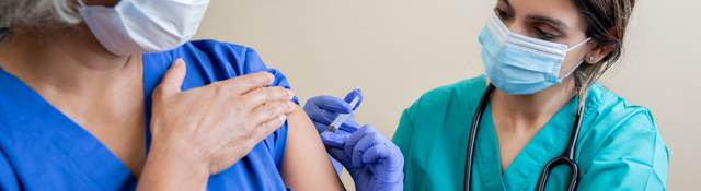 Nurse provides vaccine to elderly woman