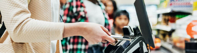 woman using a mobile phone to pay for groceries