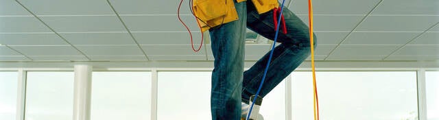 Man on step ladder, working through gap in ceiling, low section