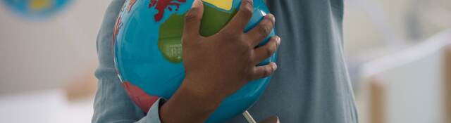 Child holding a toy ball.